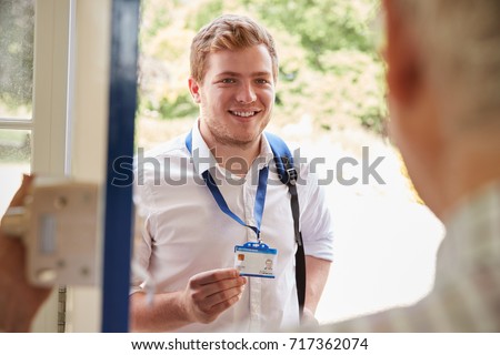 Male care worker showing ID to senior man at his front door