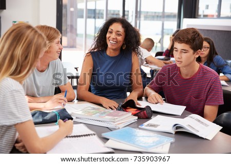 Teacher studying school books in class with high school kids