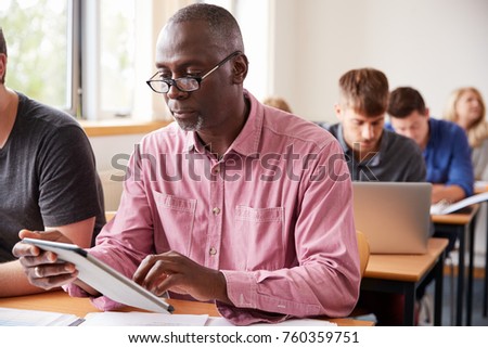 Mature Student Using Digital Tablet In Adult Education Class