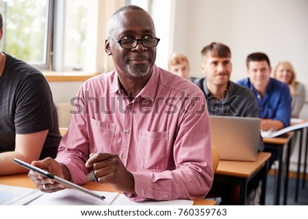 Mature Student Using Digital Tablet In Adult Education Class