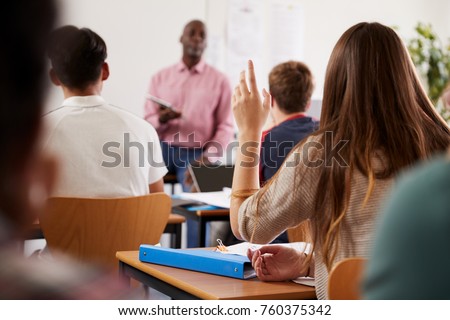 Rear View Of Female College Student Asking Question In Class
