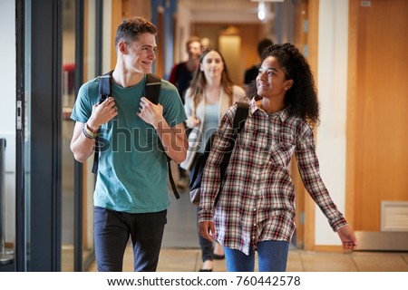 Group Of College Students Walking Through College Corridor