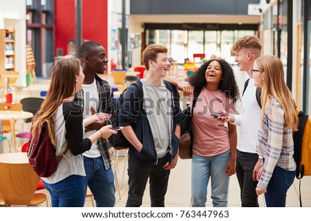 Student Group Socializing In Communal Area Of Busy College