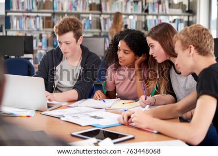 Group Of College Students Collaborating On Project In Library