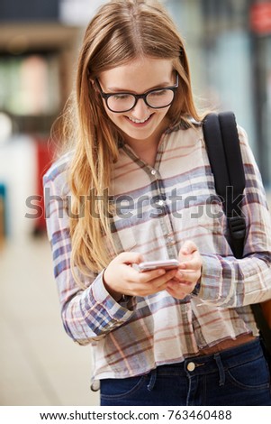 Female College Student Reading Text Message On Mobile Phone