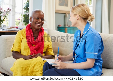 Female Community Nurse Visits Senior Woman At Home