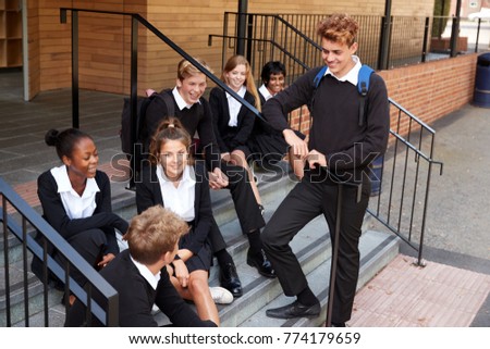 Group Of Teenage Students In Uniform Outside School Building