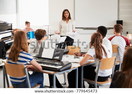 Teenage Students Studying In Music Class With Female Teacher