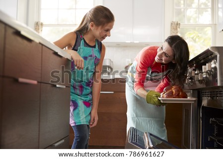 Mother showing daughter freshly baked bread from the oven