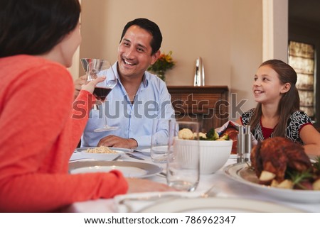 Happy Jewish family raising glasses before Shabbat meal