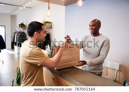 Man serving customer at the counter in a clothing store
