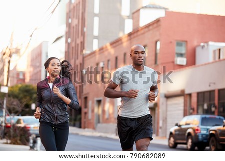 Young black couple jogging in Brooklyn street, close up