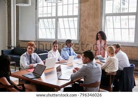 Colleagues turning to a woman at a boardroom meeting