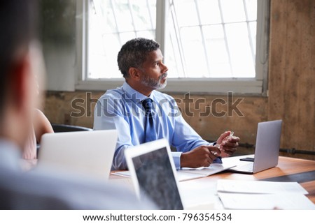 Close up of businessman listening at a boardroom meeting