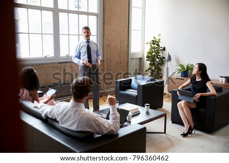 Male manager stands at an informal lounge meeting, close up