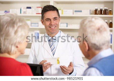 American pharmacist with senior couple in pharmacy