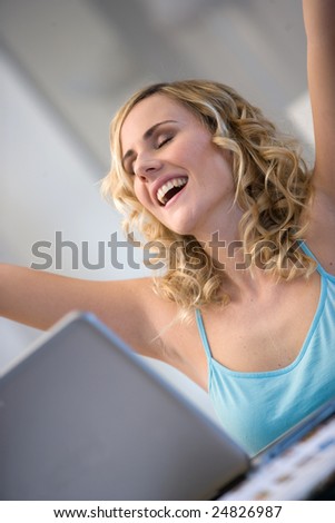 stock photo : indoors hot of a woman with arms up in front of a laptop.Concept of success,winning a bid,good news,trading stock photo : indoors hot of a woman with arms up in front of a laptop.Concept of success,winning a bid,good news,trading
