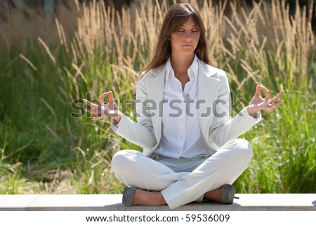 businesswoman relaxing in a zen like position outdoors