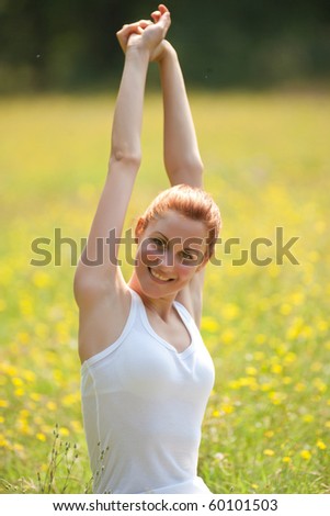 young woman doing physical exercise outdoors