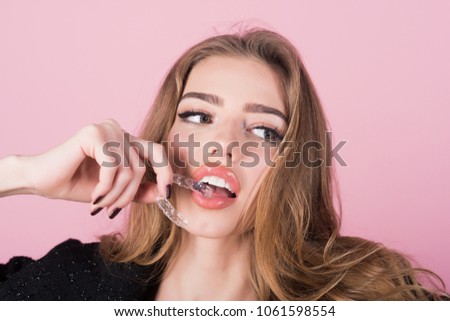 Teeth retainer for improving bite in hand of pretty girl. Teeth care. Sensative young woman holds teeth retainer. Mobile orthodontic appliance. Close-up of woman holds transparent teeth aligner.