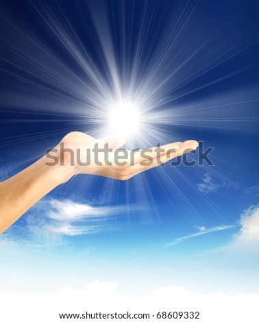 Sun in the hands on the blue sky. Freedom, harmony, spirituality concept