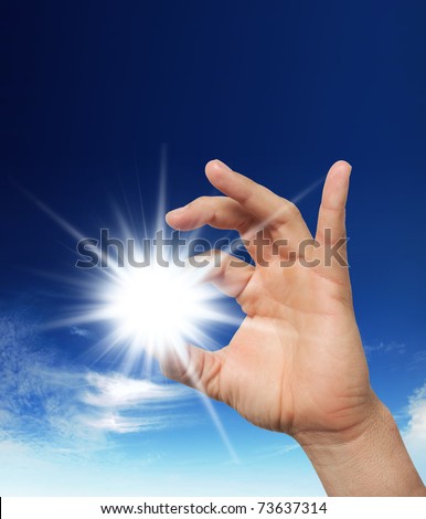 Sun in the hand on the blue sky. Freedom, harmony, spirituality concept