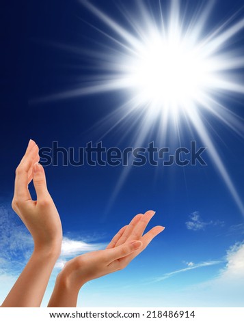 Hands, sun and blue sky with copyspace showing freedom or solar power concept