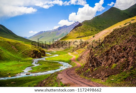 Mountain river valley road landscape. Mountain road at mountain river stream in mountain valley panorama
