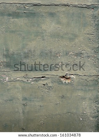 Old green wood texture, with various holes and cracks in its surface, and areas of heavily chipping green paint.