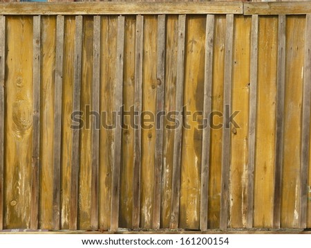 Old gold-colored paneling with thin planks at varying intervals covering gaps.