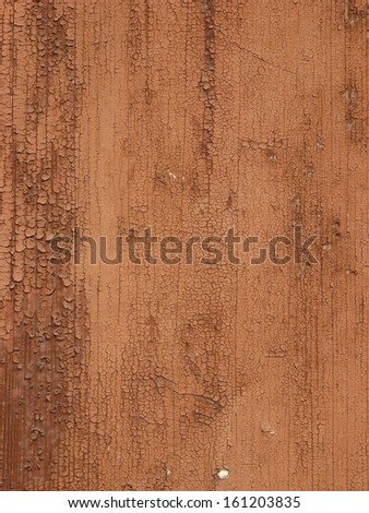 Old wood texture covered by a heavy layer of extensively cracked brown paint.