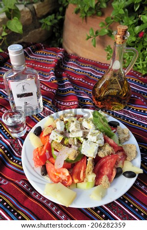 Traditional Greek Salad with olive oil and Ouzo, traditional Greek liquor