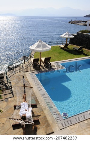 swimming pool, hammock and open air balcony at the modern luxury hotel with Aegean Sea as background, Crete, Greece