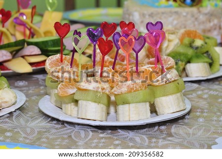 Funny canapes in the form of hearts with fruit pieces for children\'s holiday