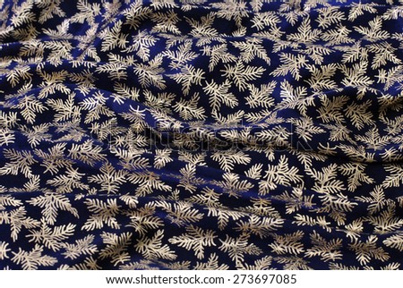 wavy background of dark-blue cloth with gold leaves