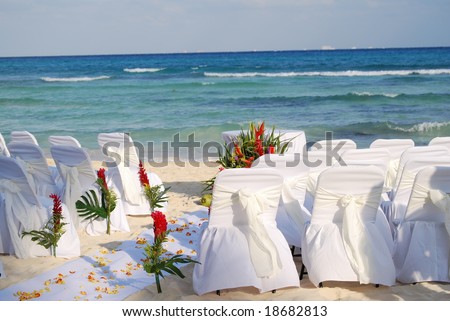 stock photo white draped chairs awaiting a Mexican beach wedding