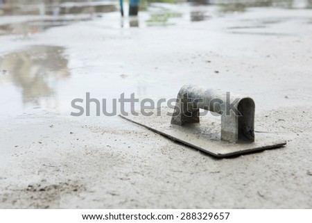 Trowel on fresh concrete at construction site