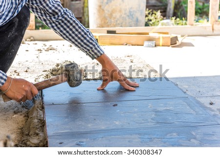 worker putting ceramist tile on the floor. Professional ceramist is laying ceramic tile on the floor
