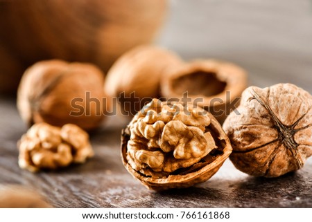 Walnuts kernels in wood bowl on dark desk, Walnut with color background, Whole walnuts in wood vintage bowl.