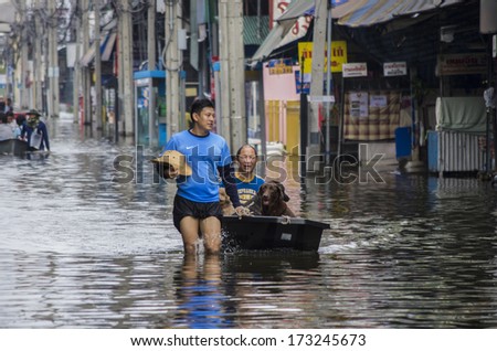 BANGKOK, THAILAND - NOV 5, 2011: People and dogs with their transportation during a big flooding in Thailand. At Phongphet junction, Ngamwongwan road.