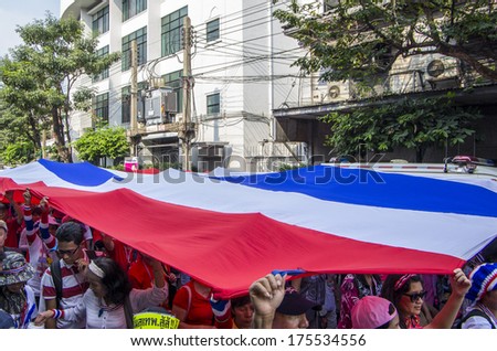 BKK - FEB 1, 2014: Anti-government protesters march through Bangkok\'s Chinatown with the big national flag.