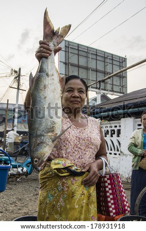 MYANMAR, BURMA - FEB 18, 2014 :A market woman with a big fish in the Dawei morning fresh market.