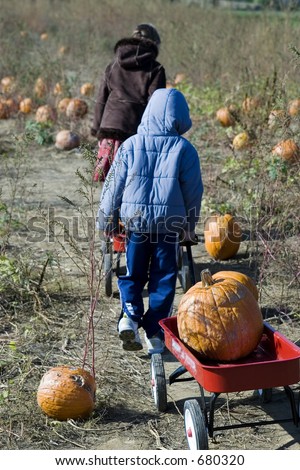 brother and sister picking pumpkins