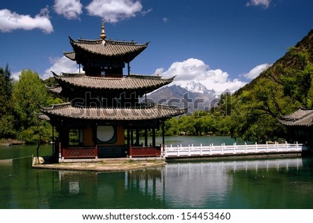 LIJIANG, CHINA:  THE LOVELY WATER PAGODA IN BLACK DRAGON POOL PARK WITH DISTANT JADE DRAGON SNOW MOUNTAIN