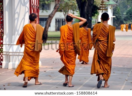 BANG PA-IN, THAILAND:  Teenaged novice monks wearing orange-coloured robes and sandals at Wat Niwet Thamaprawat built by King Rama V on a small island opposite the summer royal palace