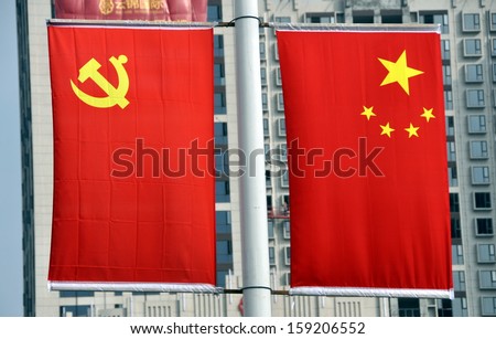 PENGZHOU, CHINA:  The Chinese flag with its symbolic five yellow stars against a red background and its counterpart with the Communist Party hammer and sickle hang from a yard-arm.