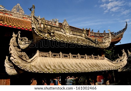 PENGZHOU, CHINA:  Decorative flying eave roofs on both an incense burner and great hall at the Shi Fo Buddhist countryside temple