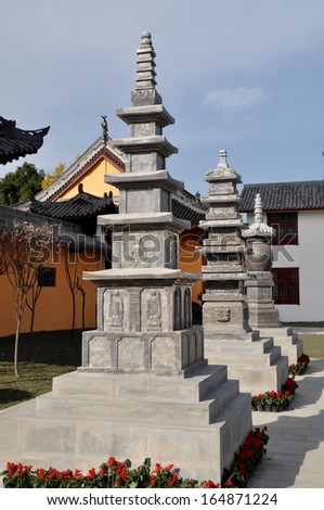 PENGZHOU, CHINA: A row of stone pagodas decorated with bas relief Buddha figures at the Long Xing Monastery