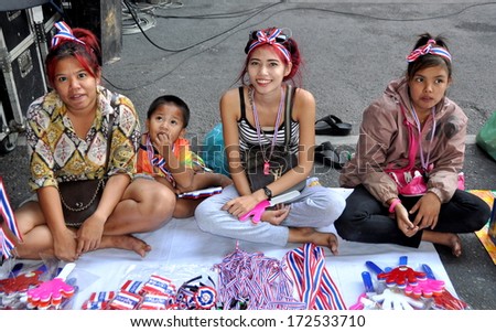 Bangkok, Thailand January 15, 2014:  Three women and a little boy selling Shut Down Bangkok souvenirs on Sukhamvit Road at Asok