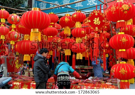 Pengzhou, China January 22, 2014: Husband and wife shopping for Chinese New Year decorations at a vendor\'s street booth